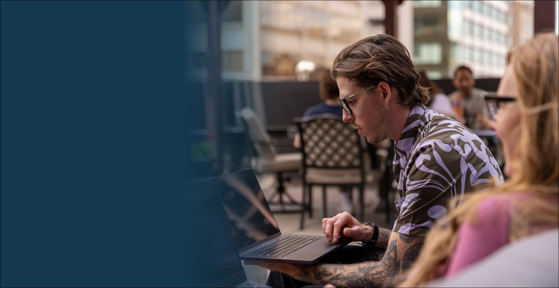 Professional guy working on his laptop outside a cafe.